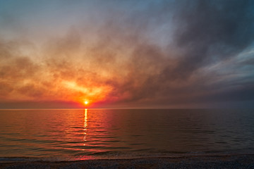 Sea sunset. Smoke wildfires sweeping across the sky.