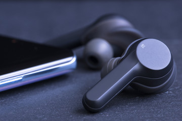 Wireless in ear buds or headphones near a mobile phone display