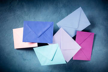 C6 envelopes flying in the air over a blue background, of various colors