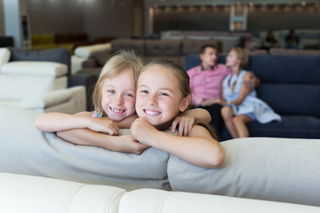 Sisters which are happy of the purchase of a new sofa