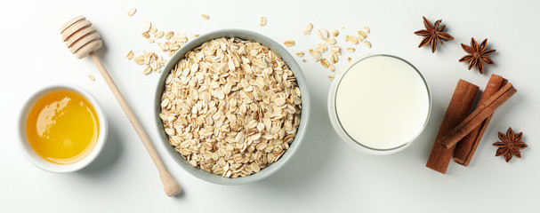 Composition with oatmeal flakes on white background, top view. Cooking breakfast