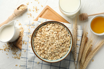 Composition with oatmeal flakes on white background, top view. Cooking breakfast