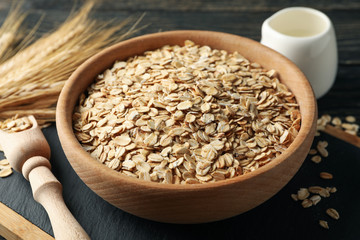 Composition with oatmeal flakes and milk on wooden background
