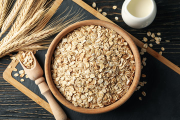 Composition with oatmeal flakes and milk on wooden background