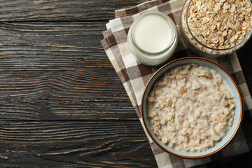 Composition with oatmeal porridge on wooden background. Cooking breakfast