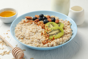 Composition with oatmeal with fruits on white background