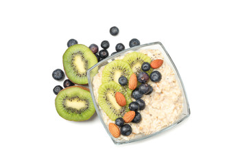 Bowl with oatmeal porridge and fruits isolated on white background