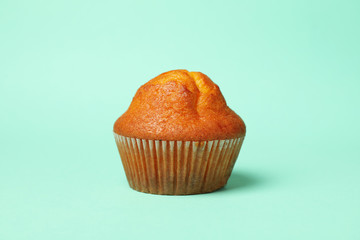 Tasty chocolate muffin on mint background, close up