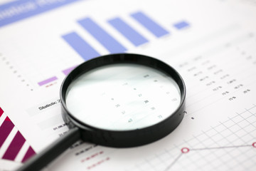 Financial statistics documents with lens at office table