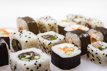 Set of japanese sushi rolls of eel, salmon with sesame seeds on a white background.
