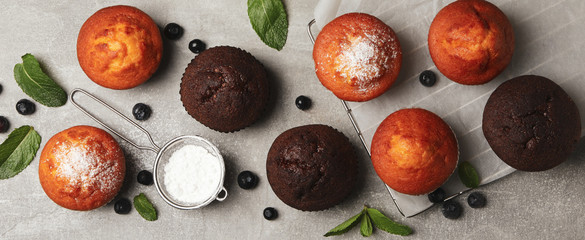 Composition with delicious muffins on gray background, top view
