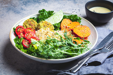 Vegan dinner. Quinoa salad with baked sweet potato, falafel, kale and pea seedlings. Healthy Falafel salad bowl.