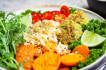 Vegan dinner. Quinoa salad with baked sweet potato, falafel, kale and pea seedlings. Healthy Falafel salad bowl.