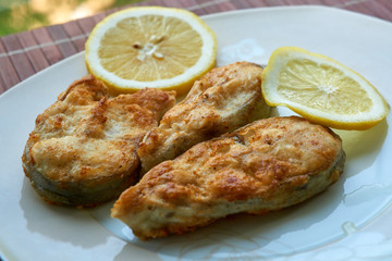 Pieces of fried fish with lemon wedges.
