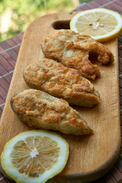 Pieces of fried fish with lemon wedges.
