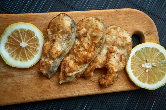 Pieces of fried fish with lemon wedges.