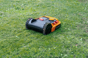 Robotic lawnmower at work on a spring lawn