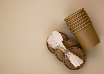 Eco-friendly food packaging and wooden spoons for catering and street fast food on a beige background with copy space. Cleanliness of the planet, care for nature and the concept of waste disposal