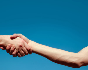 handshake between two men. Two hands. Love couple. Man and woman hands. Sky background. 