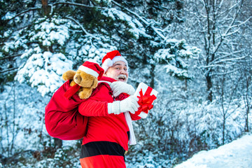 Winter landscape of forest and snow with santa claus. Cold December. Santa Claus comes with gifts from the outside.