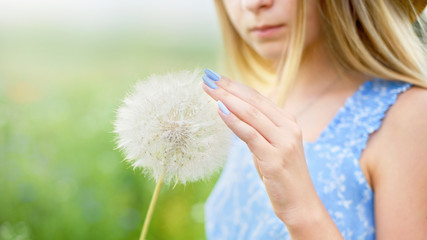 Summer portrait of girl with big dandelion. Close up photo of flower. Allergy free concept. Freedom