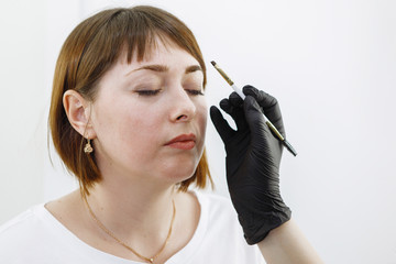 Cosmetic eyebrow care in a beauty salon.