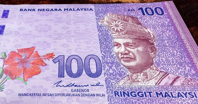 Extreme close up footage, panning over one hundred Ringgit Malaysia. Detailed macro capture of new RM 100. Macro shot from the front of Malaysian money with the portrait of the first King or Agong. 