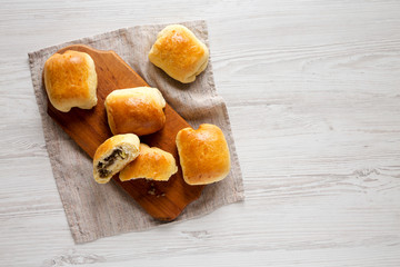 Home-baked Beef Russian Bierocks on a rustic wooden board on a white wooden background, top view. Flat lay, overhead, from above. Copy space.