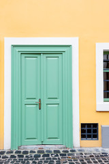 Old wooden door close-up on a background of a wall .