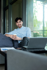 Asian business male using laptop  in the indoors