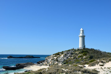 Fototapeta na wymiar White lighthouse beside the sea