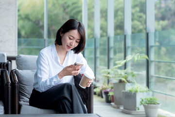 Asian business woman using mobile phone  in the outdoors