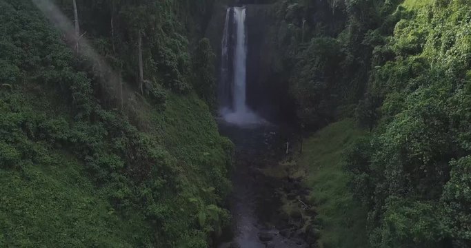 Aerial pan of waterfall in the tropical Pacific 
