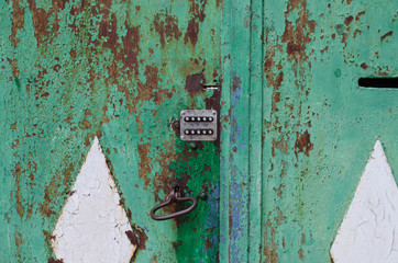 Vintage handle on the door. The old iron door. Metal gate. Cracked paint.