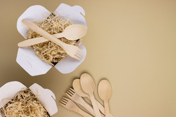 eco food containers and eco food containers with wooden spoons and forks on a light background with space for text. caring for nature, preserving the purity of the planet
