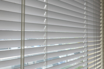 Close up window with white venetian blinds.