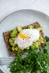 Tasty sandwich with poached egg and avocado on mrble background with copy space