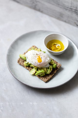Tasty sandwich with poached egg and avocado on mrble background with copy space