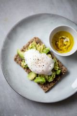 Tasty sandwich with poached egg and avocado on mrble background with copy space
