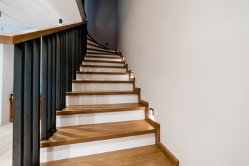 Metal handrails and wooden stairs. Combination of types of materials. Black brushed metal. Loft and...