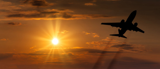 Airplane taking off at sunset. Silhouette of a big passenger or cargo aircraft, airline....