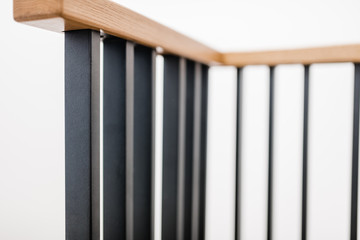 Metal handrails and wooden stairs. Combination of types of materials. Black brushed metal. Loft and high-tech