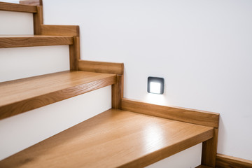 stylish wooden stairs in the apartment with handmade black metal railings