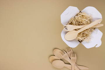 eco food containers and eco food containers with wooden spoons and forks on a light background with space for text. caring for nature, preserving the purity of the planet