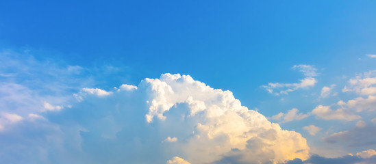 Blue sky with fluffy low clouds and orange light