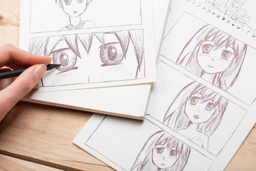 Artist drawing an anime comic book in a studio.
