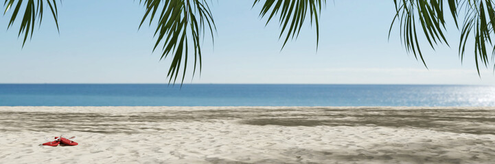 Fototapeta na wymiar Flip flops on empty beach by the sea during summer vacation