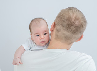 Relationship between father and newborn baby. Man holds his newborn baby son. Back view