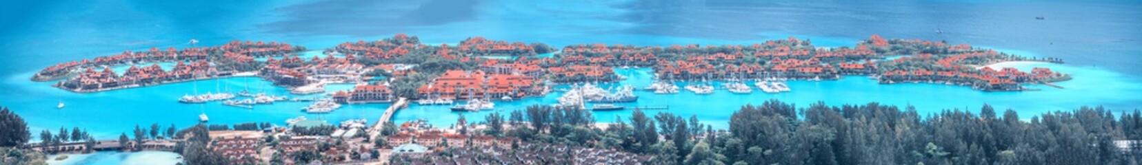 Obraz premium Aerial panoramic view of Mahe coastline, Seychelles Islands. Luxury Eden Island from Victoria viewpoint on a sunny day