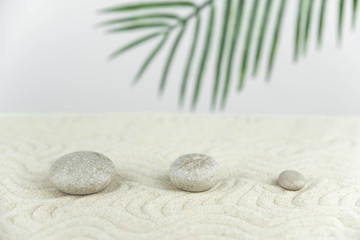 Zen garden. Pyramids of white and gray zen stones on the white sand with abstract wave drawings. Concept of harmony, balance and meditation, spa, massage, relax.